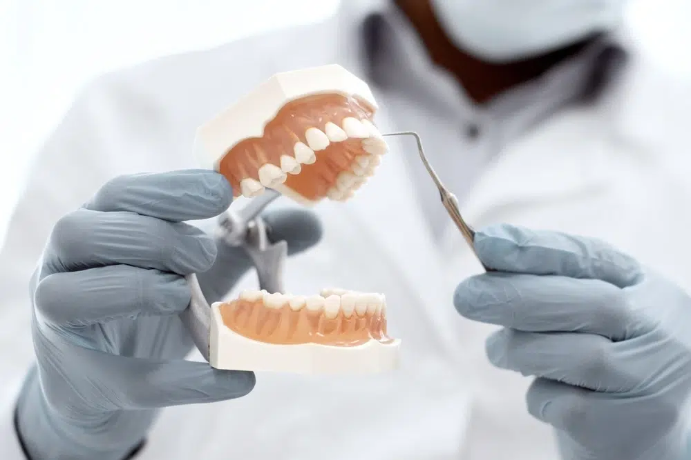 What Is Sleep Dentistry Plaza Dental dentist holding a artificial jaw and dental tool